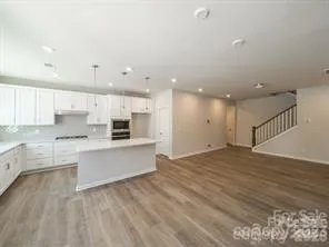 a large kitchen with kitchen island a sink stainless steel appliances and cabinets