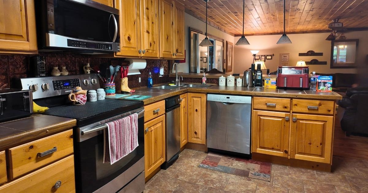 772 Rushing Road Michie, TN 38357 - Photo 4 of 19 Kitchen featuring wood cabinetry, stainless steel appliances, a tile backsplash, and a wood-paneled ceiling
