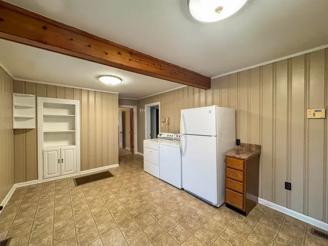a view of kitchen with refrigerator and cabinet