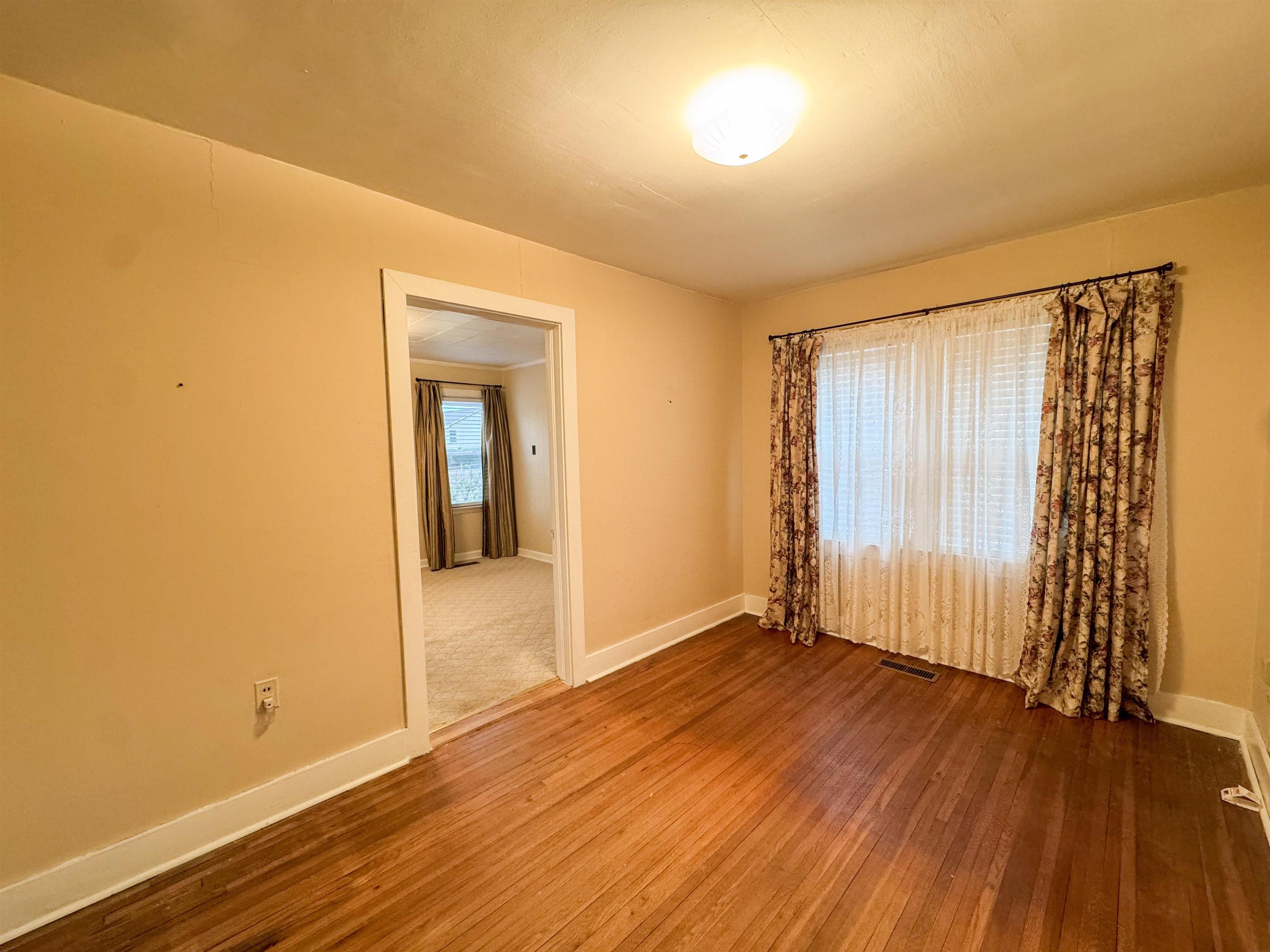 400 Park Street Covington, TN 38019 - Photo 9 of 24 a view of an empty room with wooden floor and a window