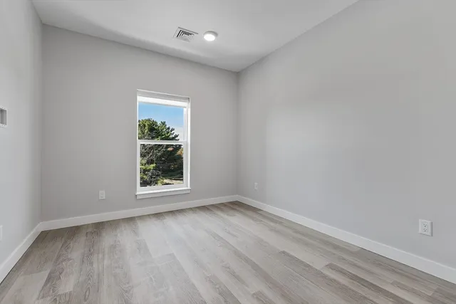 wooden floor in an empty room with a window
