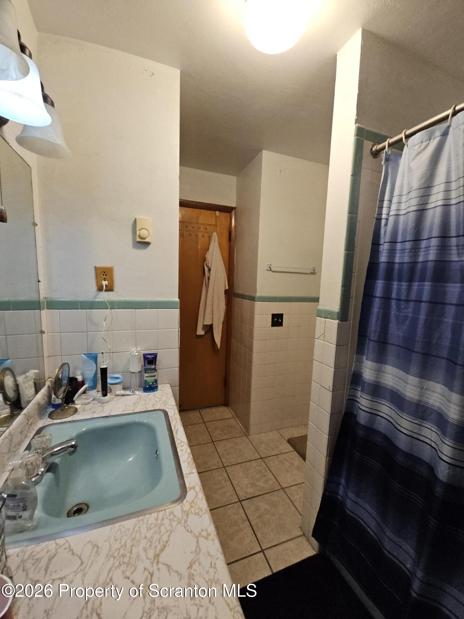 405 Baker Street Taylor, PA 18517 - Photo 18 of 36 a bathroom with a sink and mirror