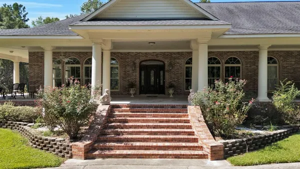 a front view of a house with potted plants