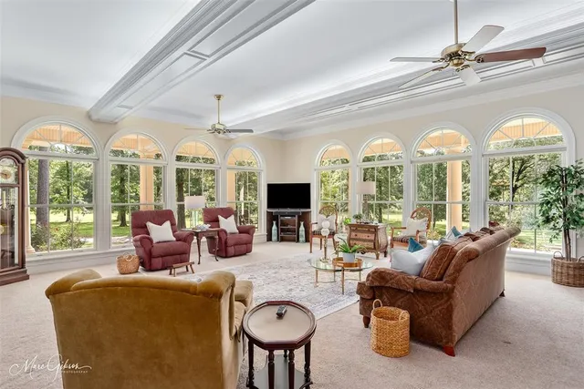 a living room with furniture a large window and a chandelier