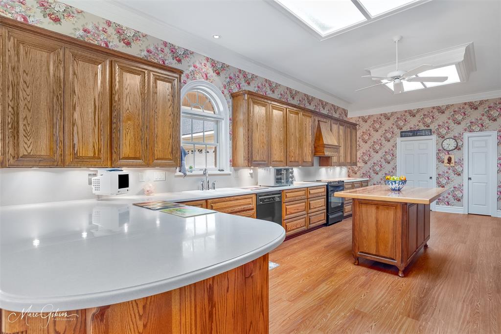 3669 Fountainbleau Road Keithville, LA 71047 - Photo 22 of 40 a large kitchen with stainless steel appliances granite countertop a sink a stove and wooden floors