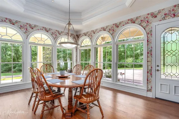 a view of a dining room with furniture a chandelier and wooden floor