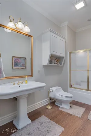 a bathroom with a sink a toilet and shower