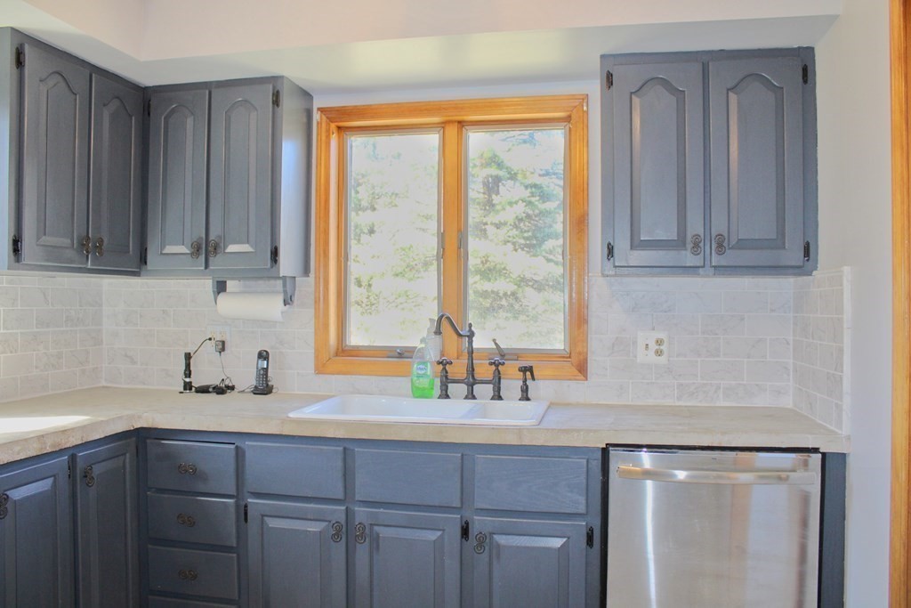32 Hemlock Street Douglas, MA 01516 - Photo 12 of 41 a kitchen with stainless steel appliances granite countertop a sink a window and cabinets