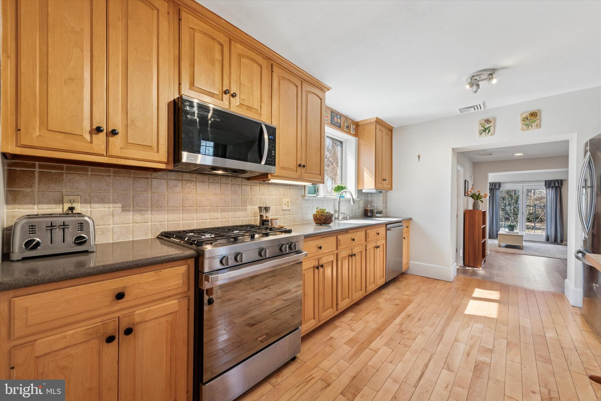48 Old Eagle School Road Wayne, PA 19087 - Photo 12 of 33 a kitchen with stainless steel appliances granite countertop a stove a sink dishwasher and a microwave oven with wooden floor