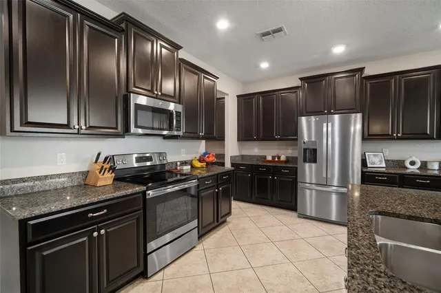 a bedroom with a bed chandelier and a lamp