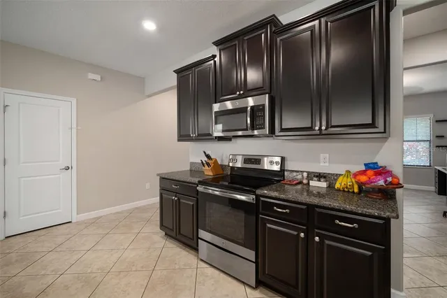 a spacious bathroom with a granite countertop sink a light fixture and a mirror