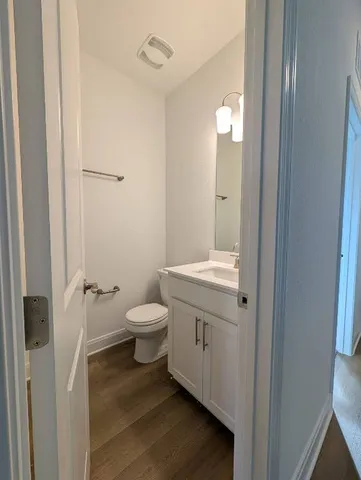 a bathroom with a granite countertop toilet a sink and a mirror