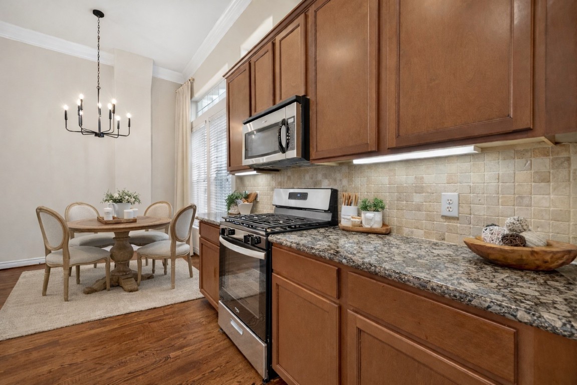 5938 Kansas Street Houston, TX 77007 - Photo 10 of 30 a kitchen with stainless steel appliances granite countertop a sink stove and cabinets
