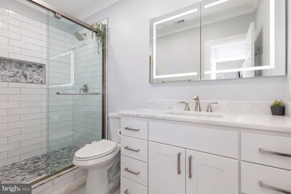 a bathroom with a sink a toilet and shower