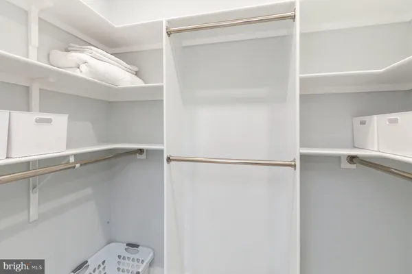 a view of walk in closet with empty racks