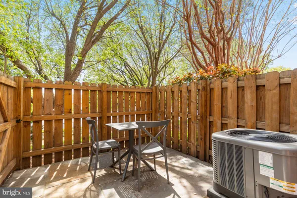 a view of a chairs and table in the back yard of a house
