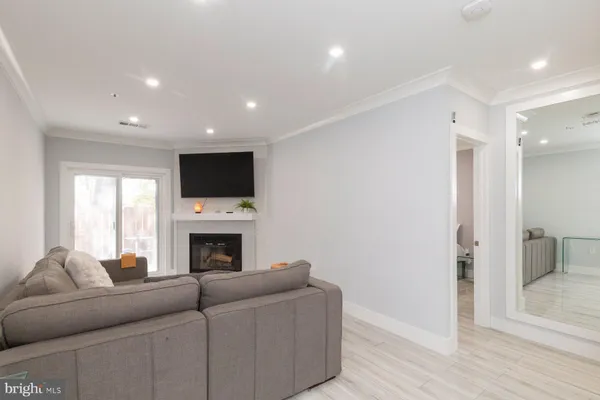 a living room with furniture a fireplace and a flat screen tv