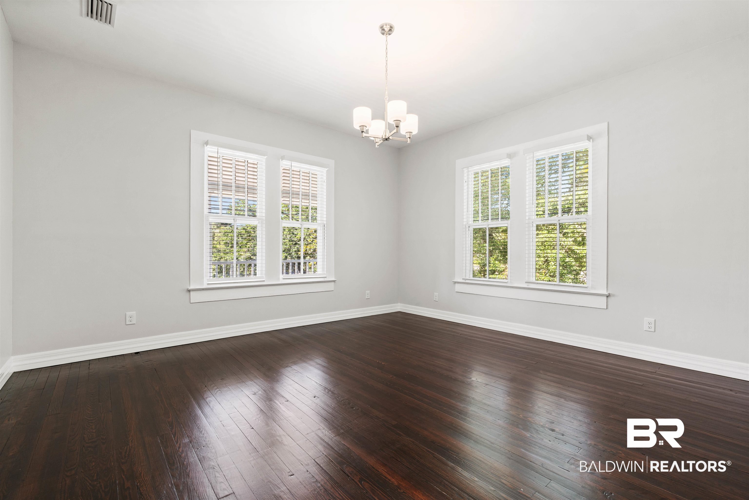407 East 2nd Street Bay Minette, AL 36507 - Photo 15 of 40 Spare room featuring dark wood-style flooring and a chandelier