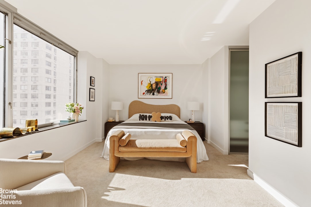 150 Columbus Avenue, Unit 18F Manhattan, NY 10023 - Photo 13 of 22 a bedroom with a bed and a large window