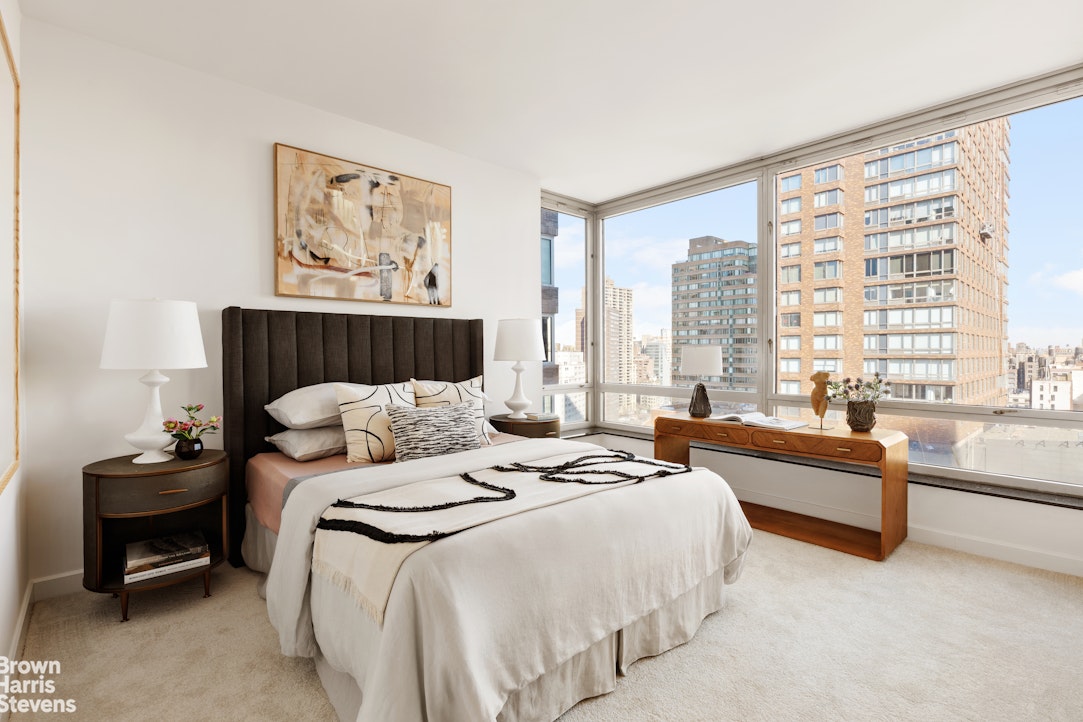 150 Columbus Avenue, Unit 18F Manhattan, NY 10023 - Photo 19 of 22 a bedroom with bed and a large window