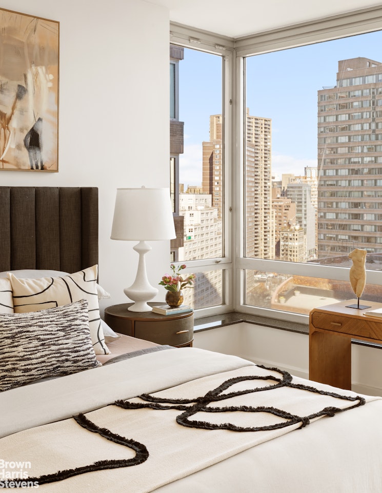 150 Columbus Avenue, Unit 18F Manhattan, NY 10023 - Photo 20 of 22 a living room with a large window and a table