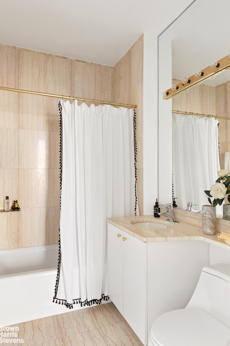 150 Columbus Avenue, Unit 18F Manhattan, NY 10023 - Photo 21 of 22 a bathroom with a granite countertop sink and a mirror