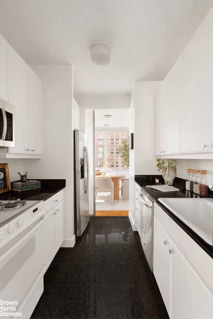 150 Columbus Avenue, Unit 18F Manhattan, NY 10023 - Photo 9 of 22 a kitchen with granite countertop a sink stove and refrigerator