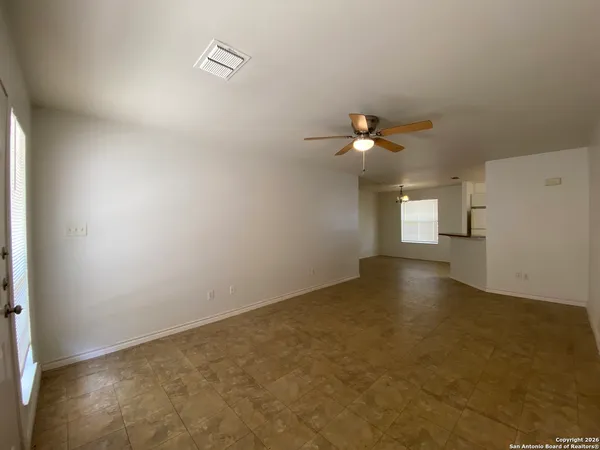 an empty room with a window and a ceiling fan