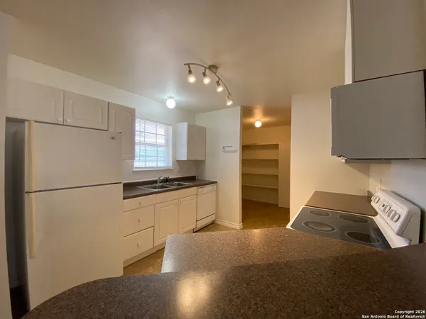a kitchen with stainless steel appliances granite countertop a refrigerator a stove and a sink