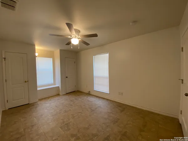 an empty room with a ceiling fan and a window