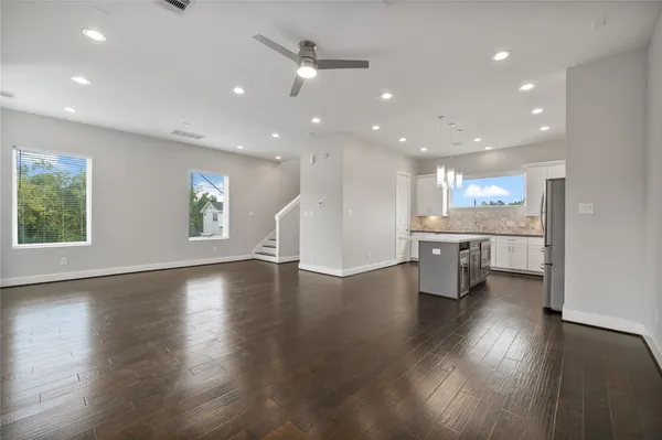 a kitchen with stainless steel appliances granite countertop a sink a stove a refrigerator and island