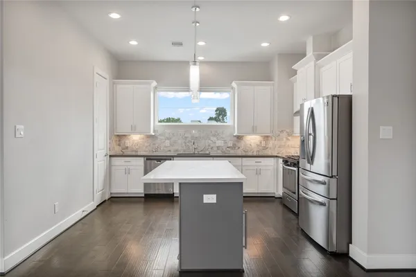 a kitchen with stainless steel appliances granite countertop a sink a stove and a refrigerator