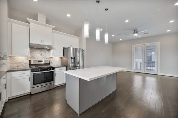 a view of a big room with wooden floors and kitchen view