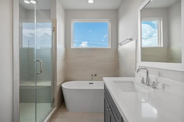 a bathroom with a sink double vanity granite tub and a mirror