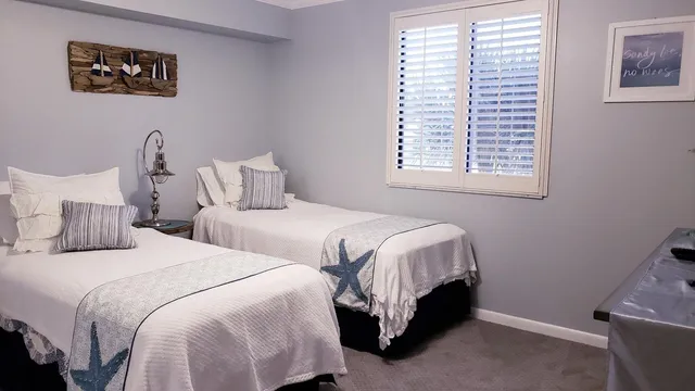 a bedroom with two beds and a window