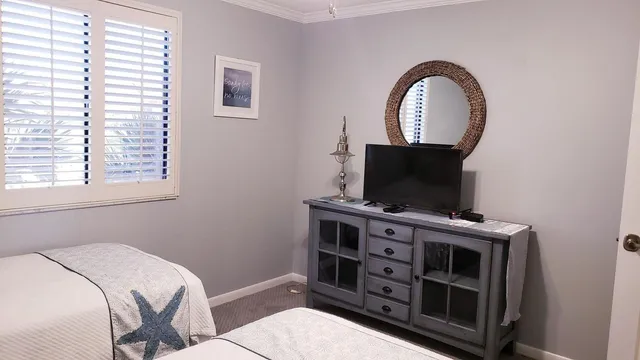a view of a bedroom with a flat tv screen and a window