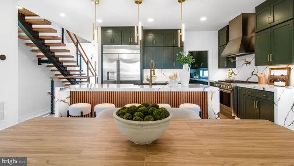 a kitchen with stainless steel appliances granite countertop a sink a stove and a wooden floors