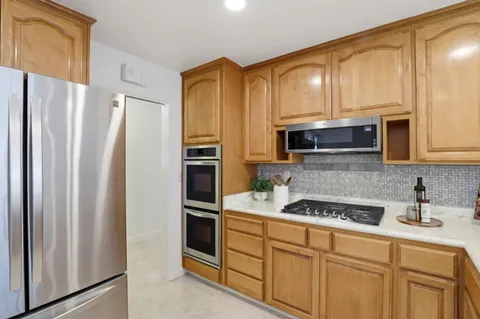 a kitchen with stainless steel appliances a refrigerator stove and microwave