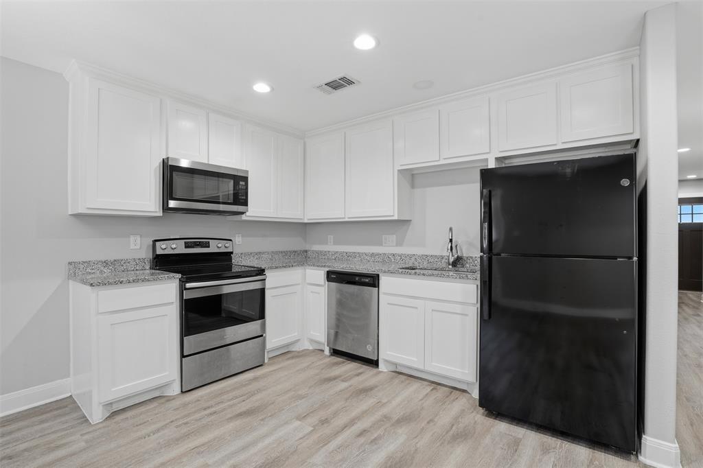 1022 West Shepherd Street, Unit 1022 Denison, TX 75020 - Photo 6 of 27 a kitchen with a refrigerator stove and microwave