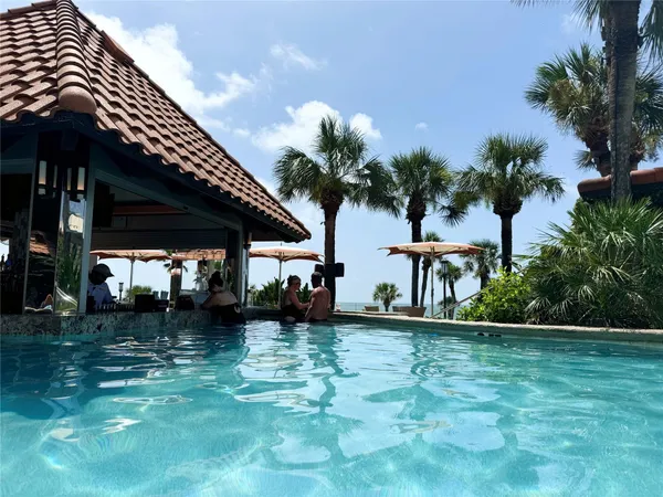 a blue swimming pool with outdoor seating and yard