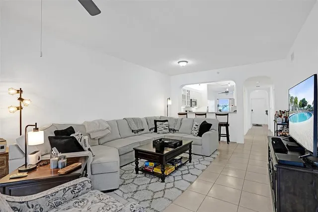a living room with furniture a flat screen tv and a table