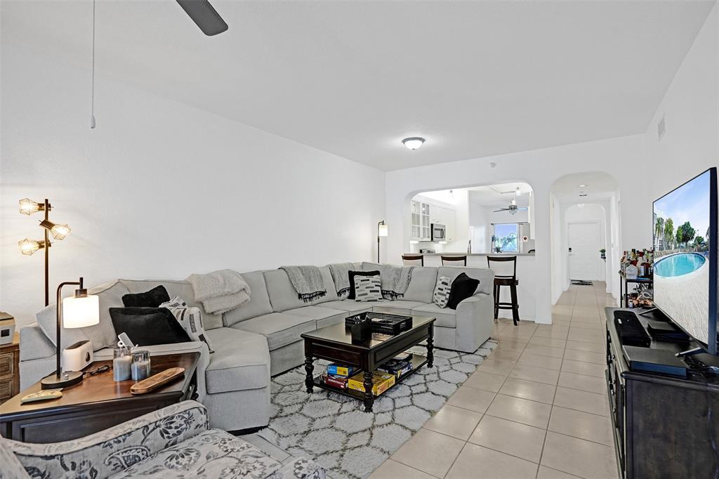 7623 Southampton Terrace, Unit 302 Tamarac, FL 33321 - Photo 12 of 43 a living room with furniture a flat screen tv and a table