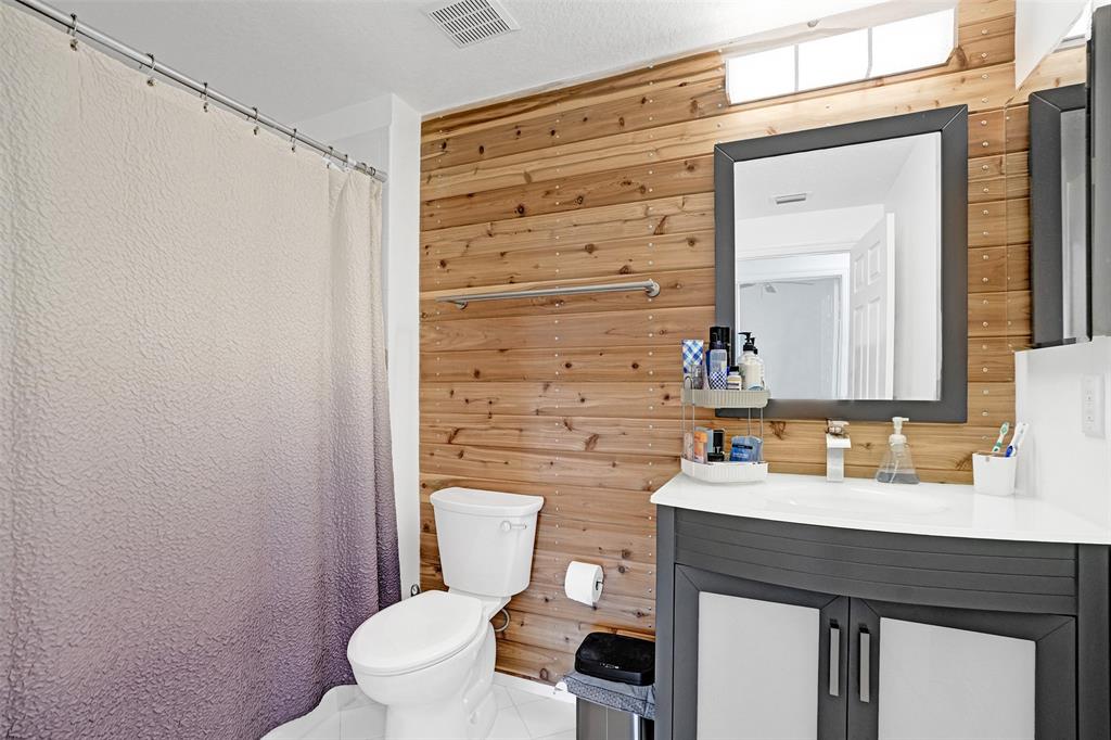 7623 Southampton Terrace, Unit 302 Tamarac, FL 33321 - Photo 15 of 43 a bathroom with a sink a toilet a mirror and shower curtain