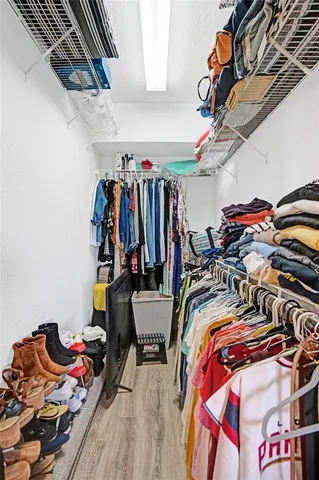 a view of walk in closet with clothes and shoes