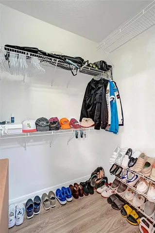 a view of walk in closet with clothes and shoes