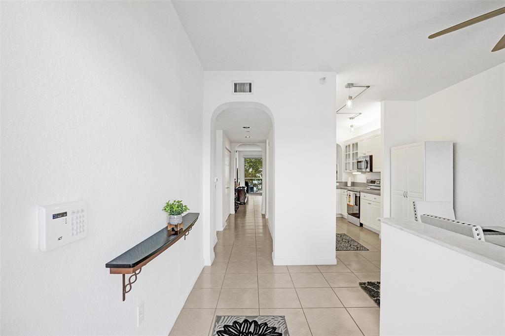 7623 Southampton Terrace, Unit 302 Tamarac, FL 33321 - Photo 5 of 43 a hallway with painting and view of living room