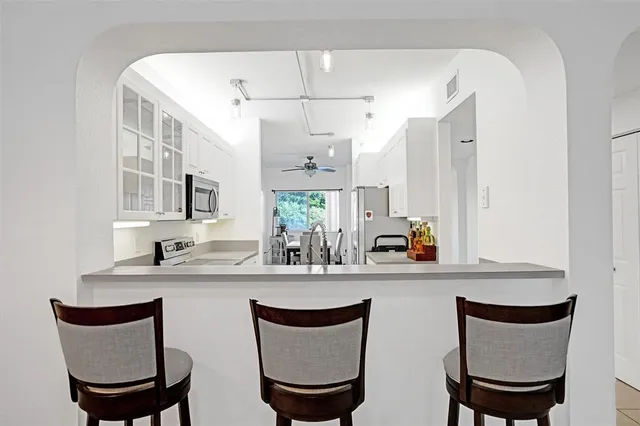 a kitchen with stainless steel appliances a dining table and chairs
