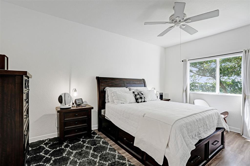 7623 Southampton Terrace, Unit 302 Tamarac, FL 33321 - Photo 10 of 43 a bedroom with a bed and a chandelier