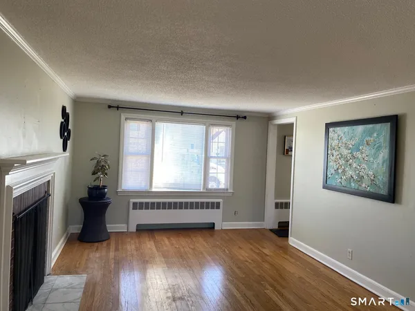 a view of an empty room with a fireplace and a window