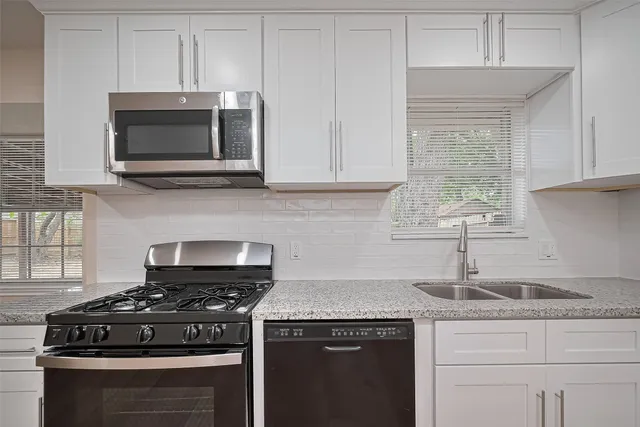 a kitchen with granite countertop a stove and a sink